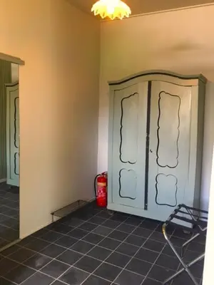 a room with a cabinet and a tile floor at B&B De Beijersche Stee, Logies aan de Waterkant in Stolwijk