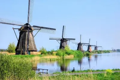 a group of windmills on a river with water at B&B De Beijersche Stee, Logies aan de Waterkant in Stolwijk