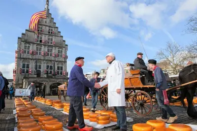 two men shaking hands in front of a carriage of pumpkins at B&B De Beijersche Stee, Logies aan de Waterkant in Stolwijk
