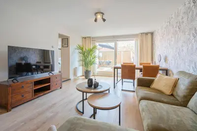 a living room with a couch and a tv at Family Stay Zandvoort - Free parking in Zandvoort