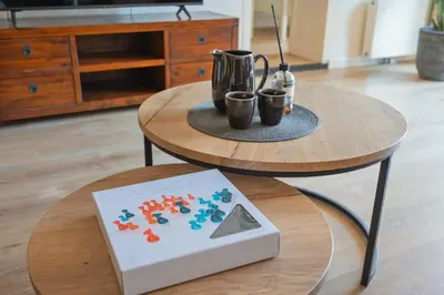 a table with a book and two cups on it at Family Stay Zandvoort - Free parking in Zandvoort