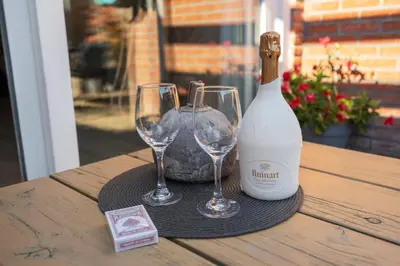 a bottle of wine and two glasses on a table at Family Stay Zandvoort - Free parking in Zandvoort