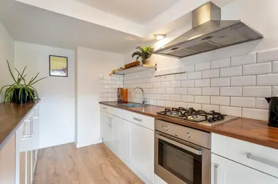 a kitchen with white cabinets and a stove top oven at Family Stay Zandvoort - Free parking in Zandvoort
