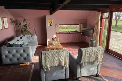 a living room with two chairs and a table at De Beijersche Stee , Landhuysje in Stolwijk