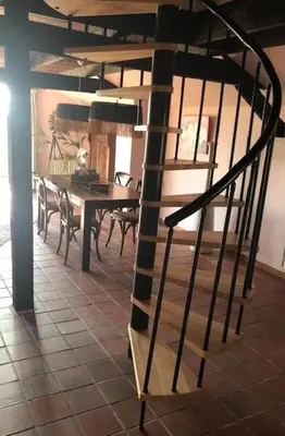 a wooden spiral staircase in a room with a table at De Beijersche Stee , Landhuysje in Stolwijk