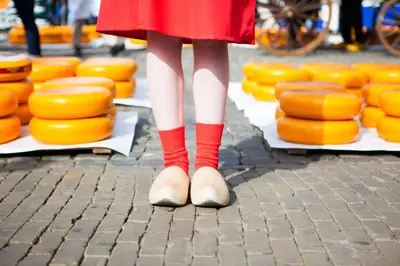 a person in a red dress standing in front of orange cheese at De Beijersche Stee , Landhuysje in Stolwijk