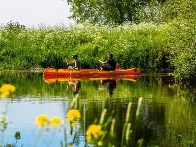 two people in a kayak on a body of water at De Beijersche Stee , Landhuysje in Stolwijk