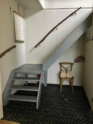 a staircase in a room with a chair and a stair case at B&B De Beijersche Stee , Logies in de Wagenschuur in Stolwijk