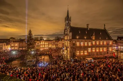 a large crowd of people in front of a building with a christmas tree at B&B De Beijersche Stee , Logies in de Wagenschuur in Stolwijk