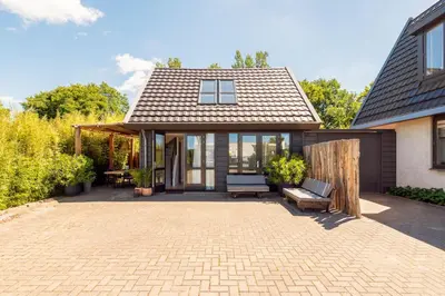 a home with a patio and a house at Berger Lodge in Alkmaar