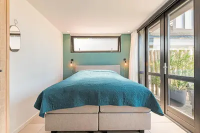 a bedroom with a bed and a large window at Berger Lodge in Alkmaar