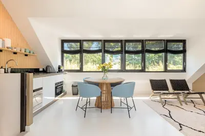 a kitchen with a table and chairs and windows at Berger Lodge in Alkmaar