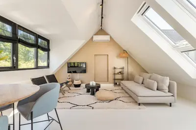 an attic living room with a vaulted ceiling at Berger Lodge in Alkmaar