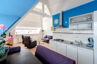 a kitchen and living room with blue ceilings at Bluys Apartment in Zandvoort