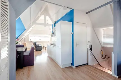 an attic room with a white and blue ceiling at Bluys Apartment in Zandvoort