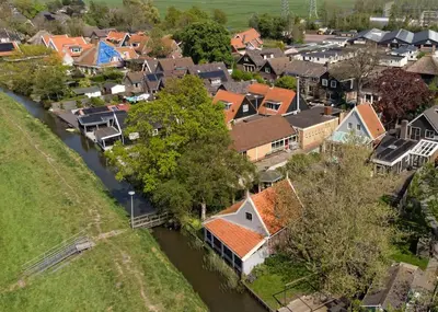an aerial view of a village with a river at Idyllisch en knus huisje met prachtige veranda. in Oterleek