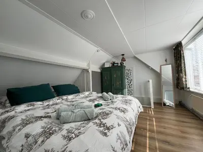 a bedroom with a large bed in a room at Tiny Beachhouse Noordwijk in Noordwijk