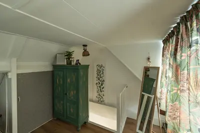 a room with a green cabinet and a staircase at Tiny Beachhouse Noordwijk in Noordwijk