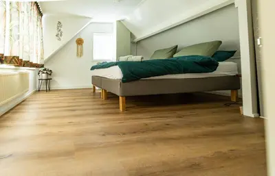 a bedroom with a bed with green pillows at Tiny Beachhouse Noordwijk in Noordwijk