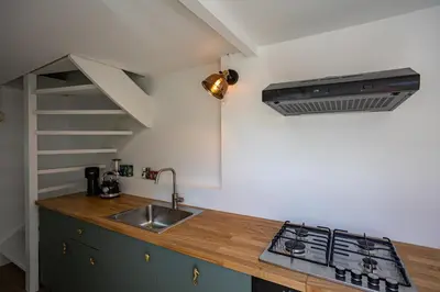 a kitchen with a sink and a stove at Tiny Beachhouse Noordwijk in Noordwijk