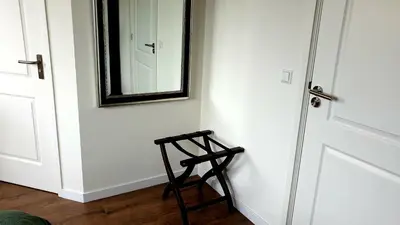 a wooden stool next to a door with a mirror at Amor Guesthouse in Amsterdam