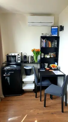 a kitchen with a table and a black table and chairs at Amor Guesthouse in Amsterdam