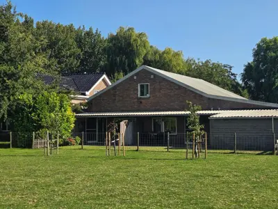 a house with a bunch of trees in the yard at Hemmer Hoeve in Hem