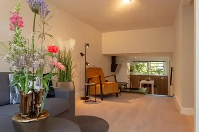 a living room with a blue couch and flowers at High Five in Zandvoort