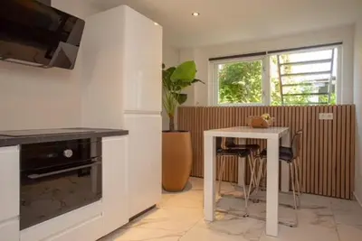 a kitchen with a table and a table and a window at High Five in Zandvoort