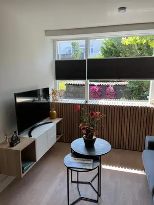 a living room with a table and a large window at High Five in Zandvoort