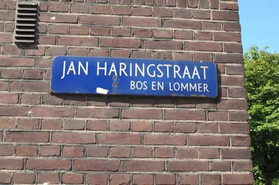 a blue sign on the side of a brick wall at Wild Roses in Amsterdam
