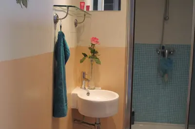 a bathroom with a sink and a vase with a flower at Wild Roses in Amsterdam