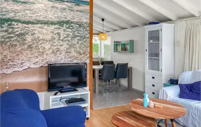a living room with a couch and a tv and a table at Nice Home In Warmenhuizen With Wifi in Schoorldam
