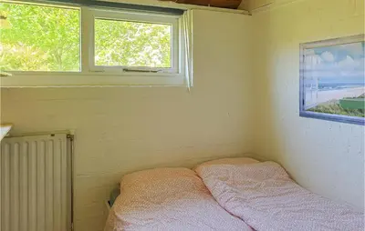 a small room with a bed and two windows at Nice Home In Warmenhuizen With Wifi in Schoorldam