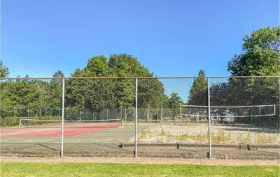 a tennis court with two tennis courts at Nice Home In Warmenhuizen With Wifi in Schoorldam