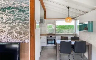 a kitchen with a table and chairs and the water at Nice Home In Warmenhuizen With Wifi in Schoorldam
