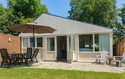 a pavilion with a table and chairs and an umbrella at Nice Home In Warmenhuizen With Wifi in Schoorldam