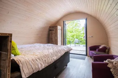 a bedroom with a bed in a room with a window at GreenFloat Boskoop - #1 in Boskoop