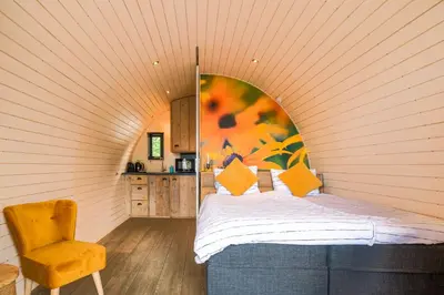 a bedroom with a bed and a chair in a room at GreenFloat Boskoop - #1 in Boskoop