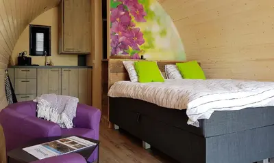a bedroom with a bed and a purple chair at GreenFloat Boskoop - #1 in Boskoop