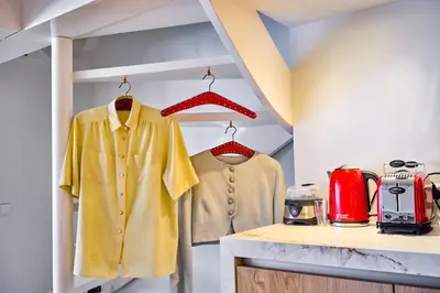 two shirts on hangers in a kitchen at Studio next to Skinny Bridge near Rembrandtsquare in Amsterdam
