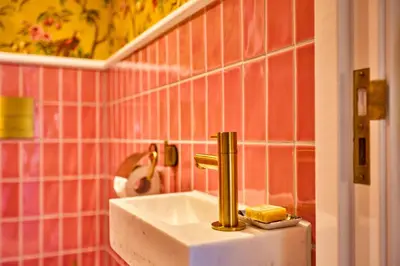 a sink in a bathroom with pink tiles at Studio next to Skinny Bridge near Rembrandtsquare in Amsterdam