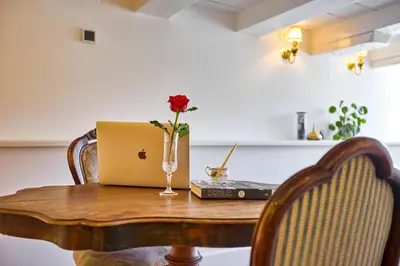 a table with a laptop and a vase with a flower on it at Studio next to Skinny Bridge near Rembrandtsquare in Amsterdam