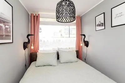a bedroom with a bed with two birds on the wall at Amsterdam Beach Apartment 52 in Zandvoort