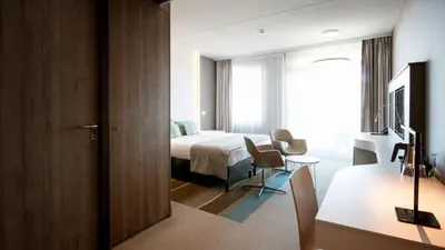 a hotel room with a bed and a desk at Strandhotel Golfzang in Egmond aan Zee