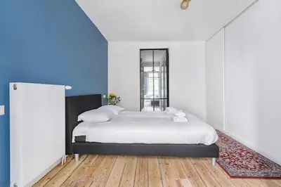 a bedroom with a large bed and a blue wall at Resident Moose in Amsterdam