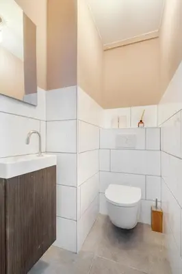 a white bathroom with a toilet and a sink at Resident Moose in Amsterdam