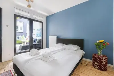 a bedroom with a large white bed with a blue wall at Resident Moose in Amsterdam