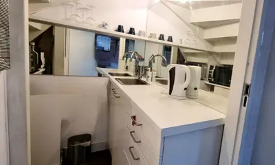 a kitchen with white cabinets and a sink at Lovely 1 bedroom apartment with garden no smoking in Amsterdam