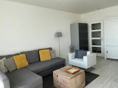 a living room with a gray couch and a white chair at Top View in Zandvoort